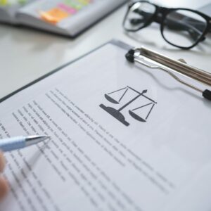 Image of a man holding a pen on top of a legal document